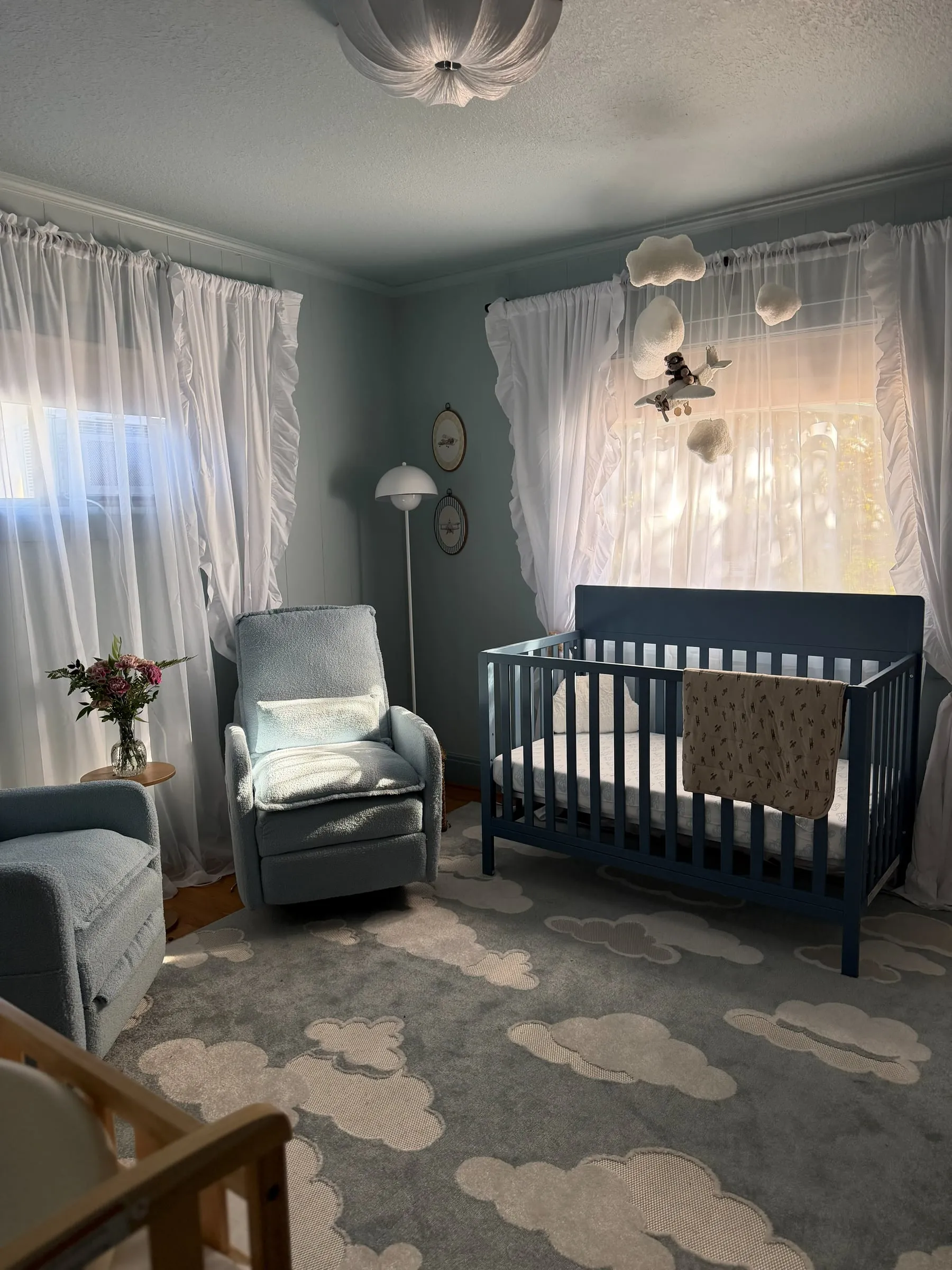 Blue nursery with cloud rug and crib